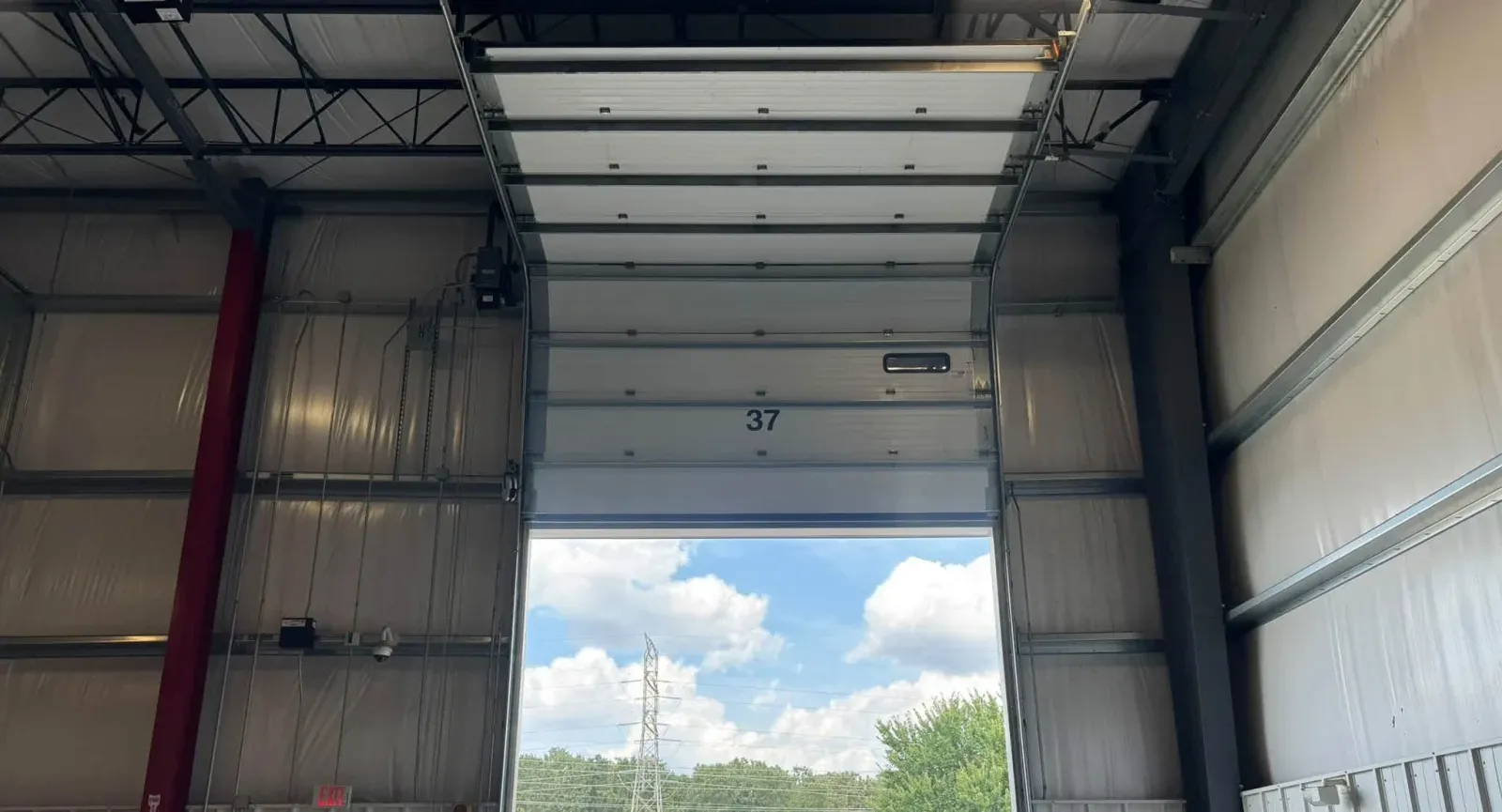 A commercial sectional door open to the yard