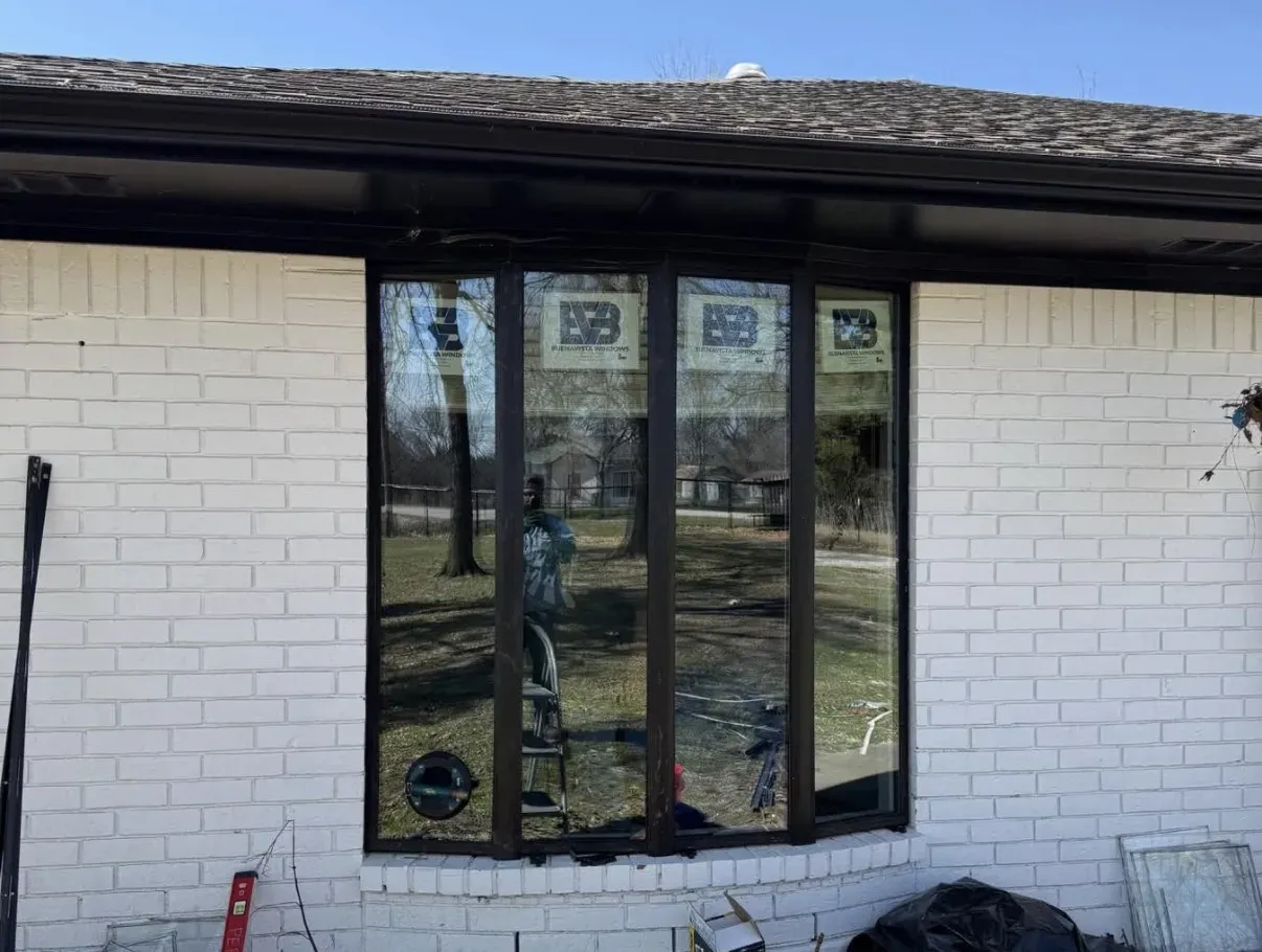 A bay of new black-framed windows in white brick