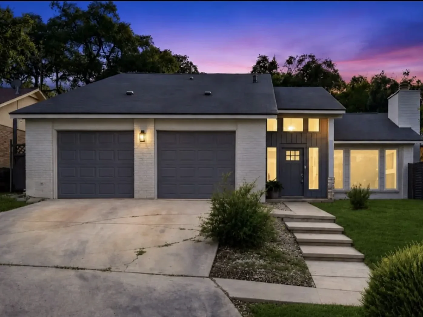 A house at dusk with its windows lit