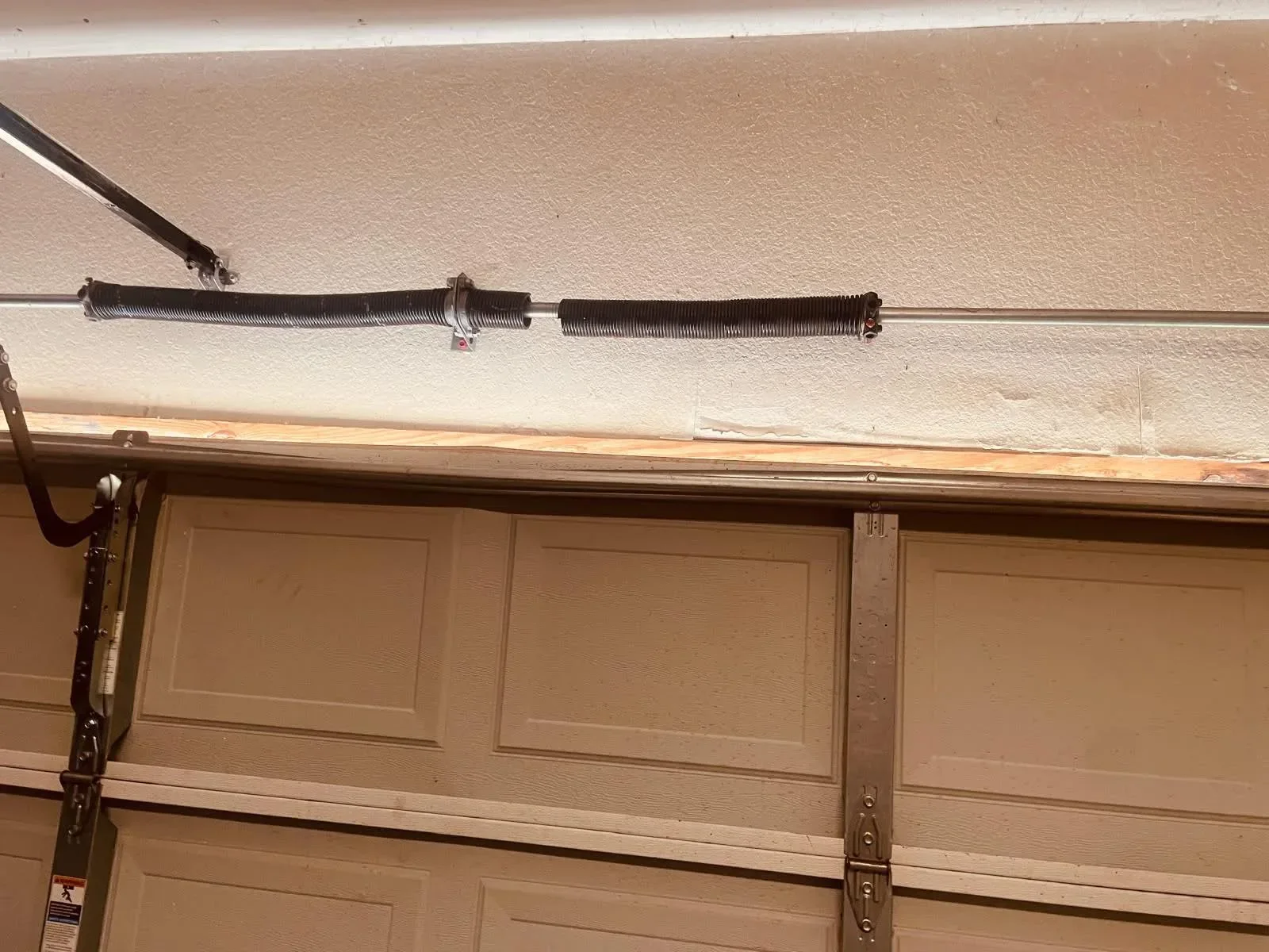 A broken torsion spring above a garage door