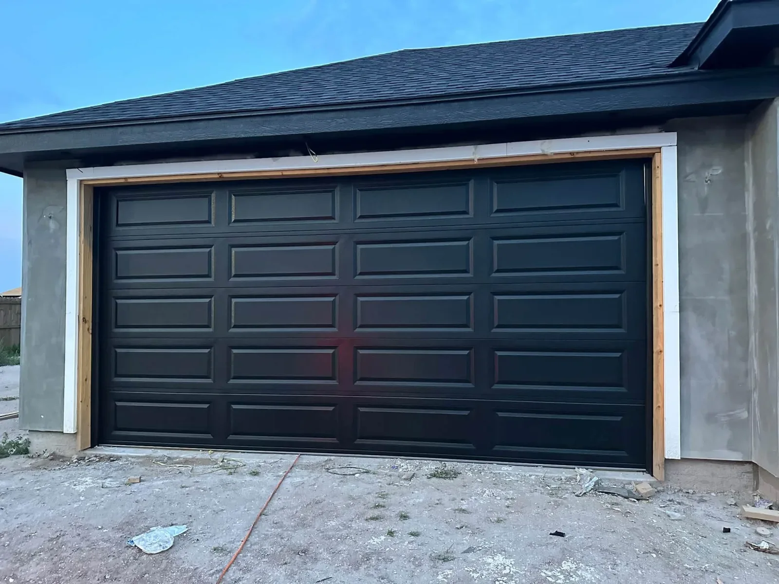 A new black long-panel garage door on a new house