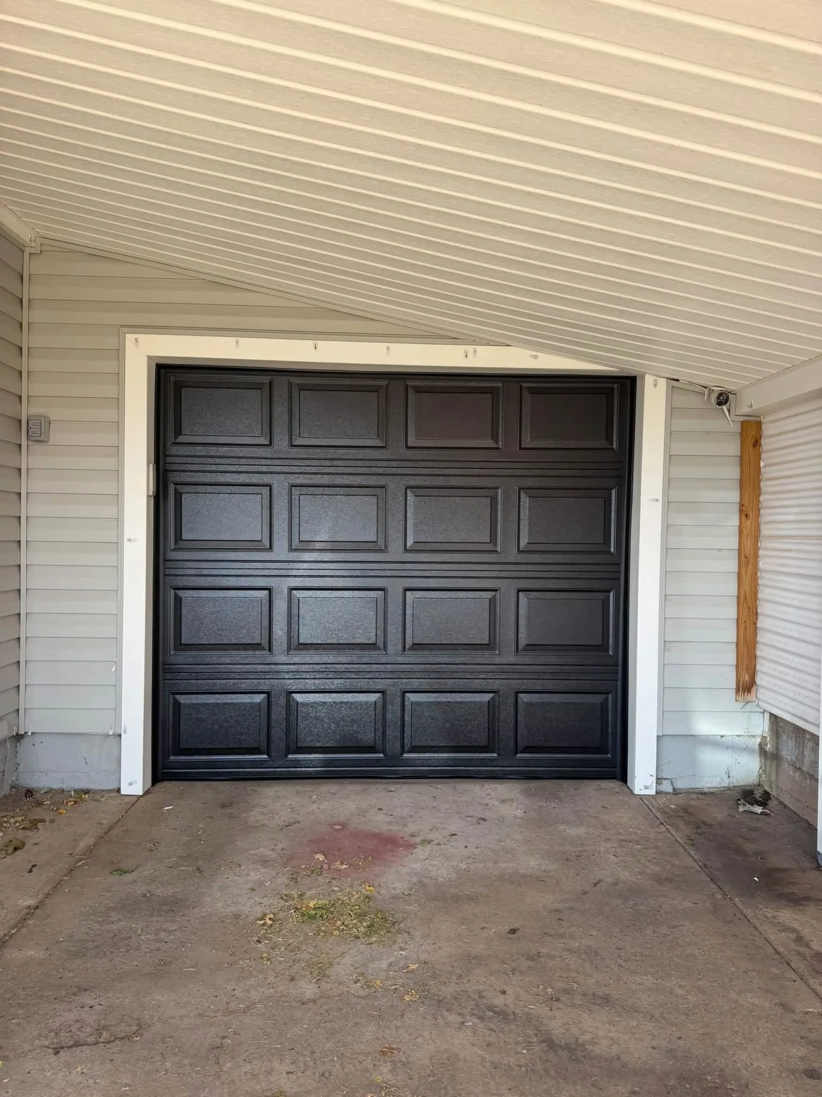 After: the same opening with a new black garage door