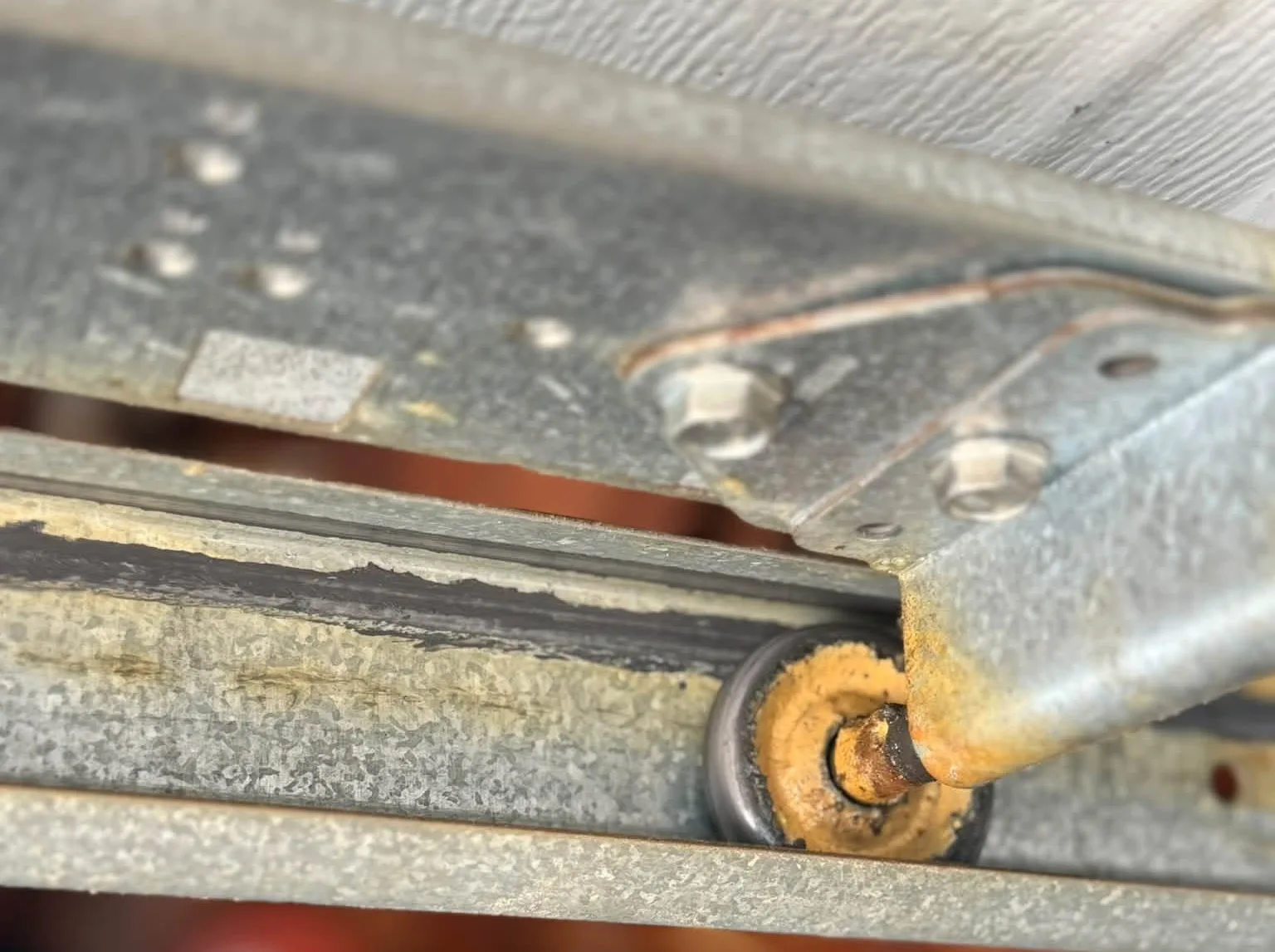 A roller running in a garage door track, close up