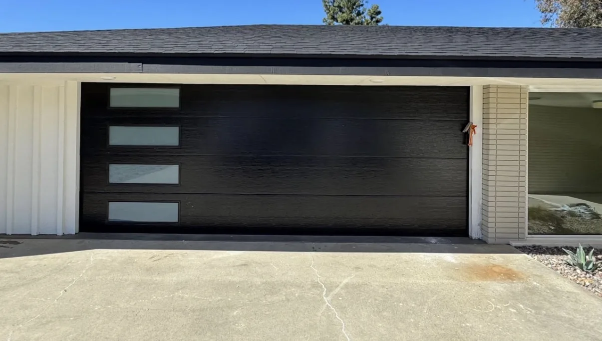 A black modern garage door with a column of windows