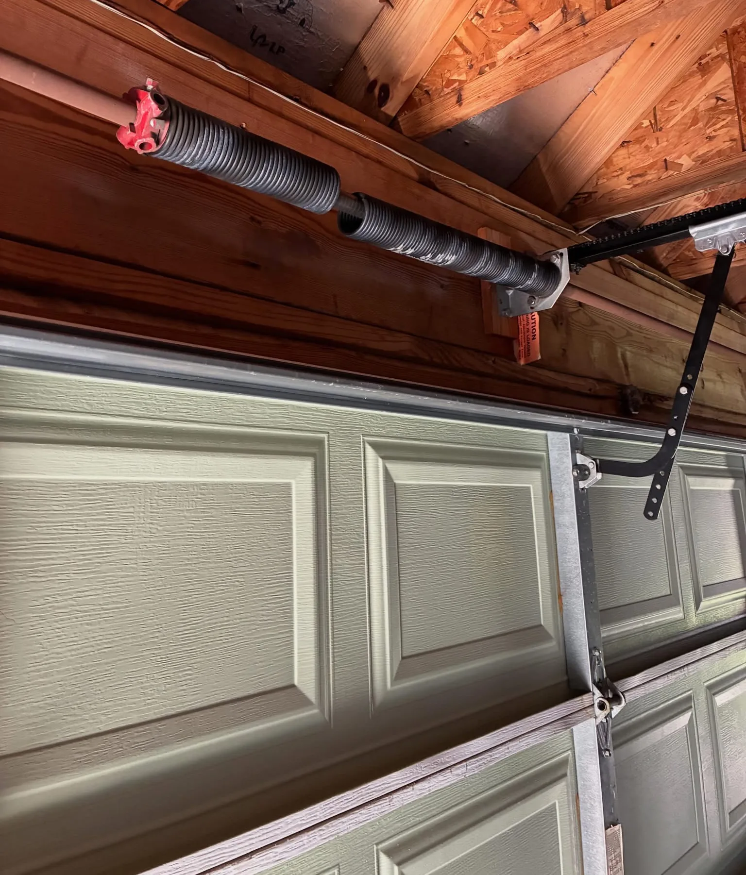 A broken torsion spring above a garage door