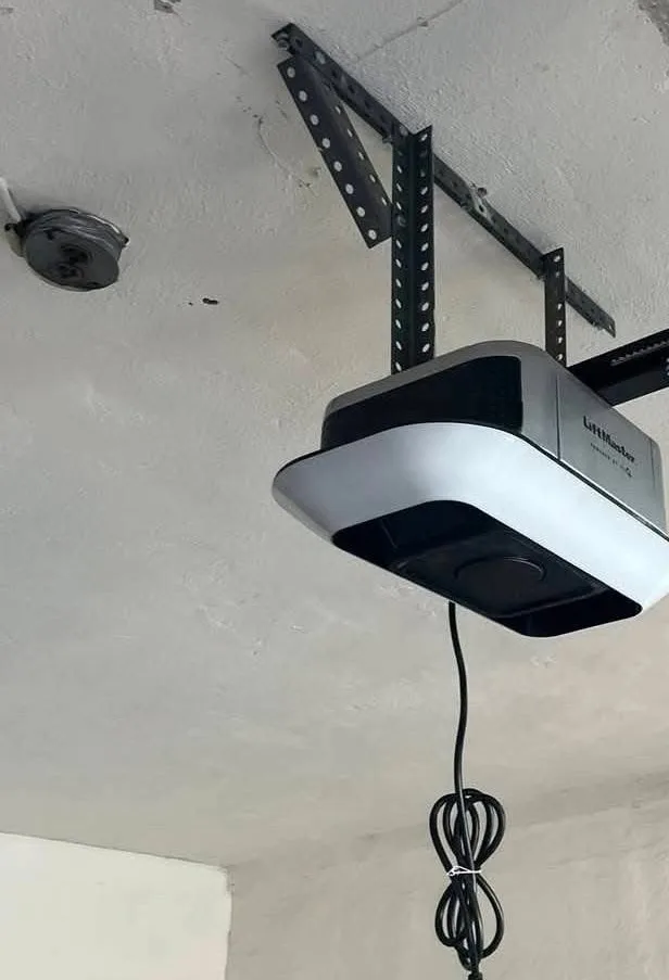 A garage door opener on the ceiling, its rail running to the door